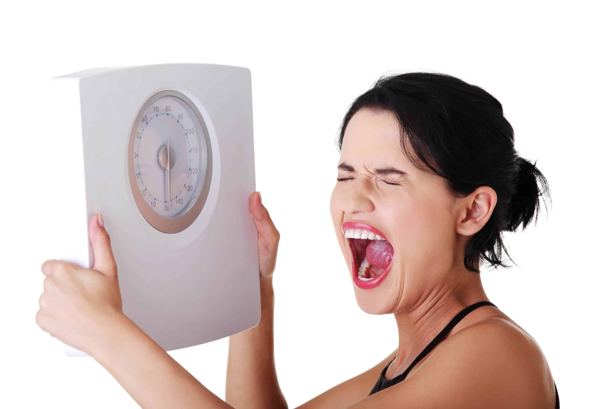 Frustrated woman with scale, weight gain